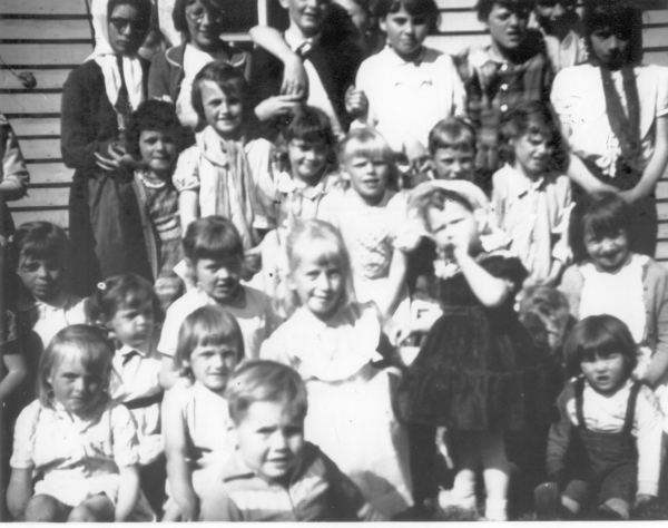 546: Madge Barry's birthday party. (circa 1963) [courtesy of Mary (Barry) Bruce] ** also see 547 **  Top row left-to-right, Ethel Lambe (kerchief), Myra Carroll (glasses), Eileen Ryan (with an  arm around her shoulder), unidentified (owner of arm), Gert Ryan (white dress),  Rose Whelan (plaid dress), unidentified, Marion Counsel (wearing tie); 2nd to top row,  Marilyn Rose (bangs, striped dress), Patricia Ryan (tall), Mercedes Ryan, Anne Marie Ryan  (blonde), ? Ryan, Linda Whelan; 3rd to top row, ? Ryan (with bangs),  ? Ryan (cheeks puffed up), Christina Ryan, Sheila Ennis (blonde), Madge Barry (white bonnet  and black dress), unidentified (boy's face), Anita Counsel (bib front); bottom row,  Ursula Ryan, Margie Ryan, Anthony Ryan (front), Joanie Ryan (with suspenders).  - Madge Barry (of Denis Patrick Barry &amp;amp; Kathleen Hayes)  - Myra Carroll (of Michael Carroll &amp;amp; Josephine Barry)  - Anita Counsel (of Michael Counsel &amp;amp; Mary Anne Barry)  - Marion Counsel (of Michael Counsel &amp;amp; Mary Anne Barry)  - Sheila Ennis (of Vince Ennis &amp;amp; Mary Carroll)  - Ethel Lambe (of James Lambe &amp;amp; Catherine Rodgers)  - Marilyn Rose (of Raymond J Rose &amp;amp; Norah Mullins)  - Anne Marie Ryan (of Maurice Ryan &amp;amp; Norah McCarthy)  - Anthony Ryan (of John Ryan &amp;amp; Joan Barry)  - Christina Ryan (of John Ryan &amp;amp; Joan Barry)  - Eileen Ryan (of Albert Ryan &amp;amp; Catherine Nolan)  - Gert Ryan (of John Ryan &amp;amp; Joan Barry)  - Joanie Ryan (of John Ryan &amp;amp; Joan Barry)  - Margie Ryan (of Maurice Ryan &amp;amp; Norah McCarthy)  - Mercedes Ryan (of John Ryan &amp;amp; Joan Barry)  - Patricia Ryan (of Maurice Ryan &amp;amp; Norah McCarthy)  - Ursula Ryan (of Maurice Ryan &amp;amp; Norah McCarthy)  - Linda Whelan (of Leo Whelan &amp;amp; Elizabeth Bishop)  - Rose Whelan (of Leo Whelan &amp;amp; Elizabeth Bishop)